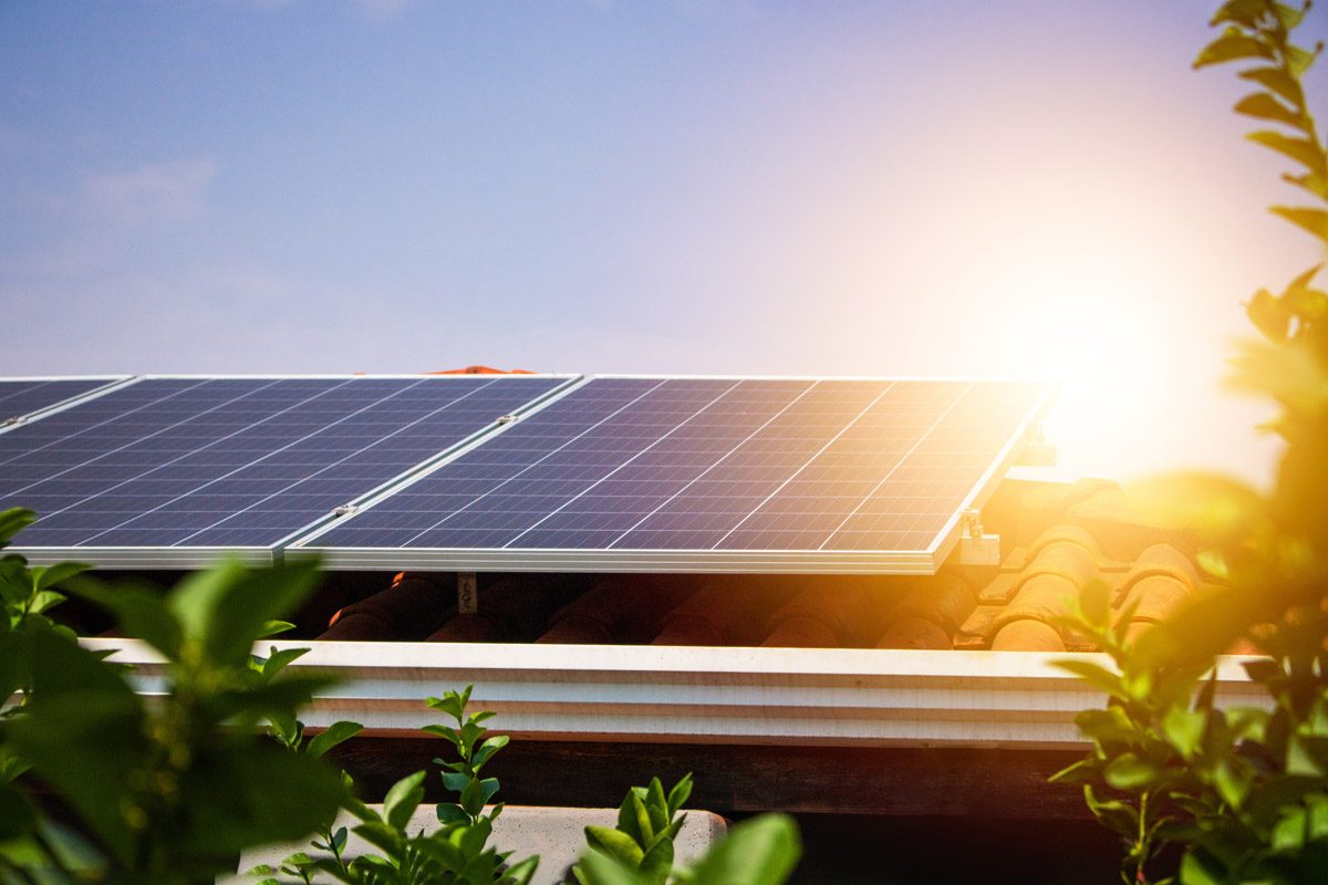 Solar panels on the red roof in a sunny and cloudy day.